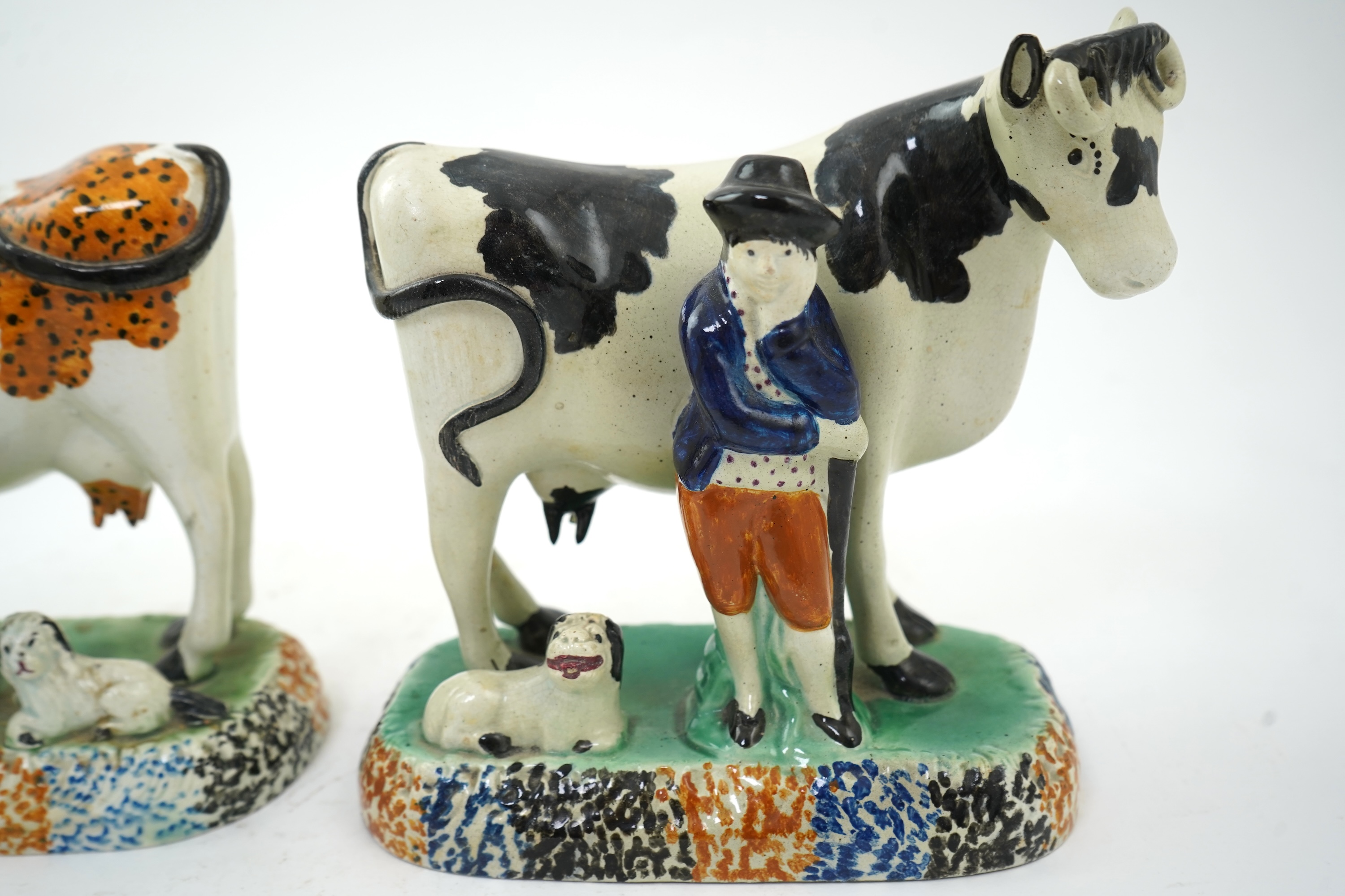 Two Yorkshire Prattware cows, with farmer or milkmaid and dog groups, c.1810